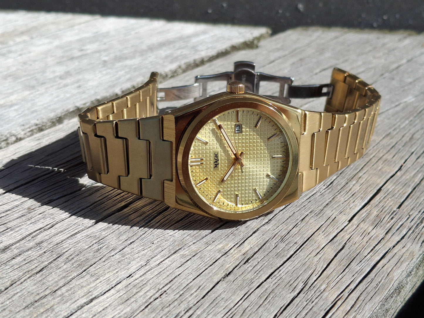 Gold wristwatch on a wooden surface